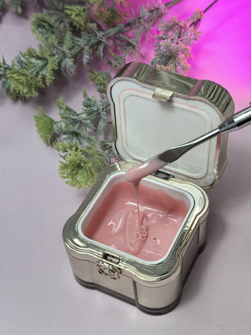 Open container of Lemmy Builder Gel 10 - Vintage Rose with gel texture and brush, surrounded by greenery.