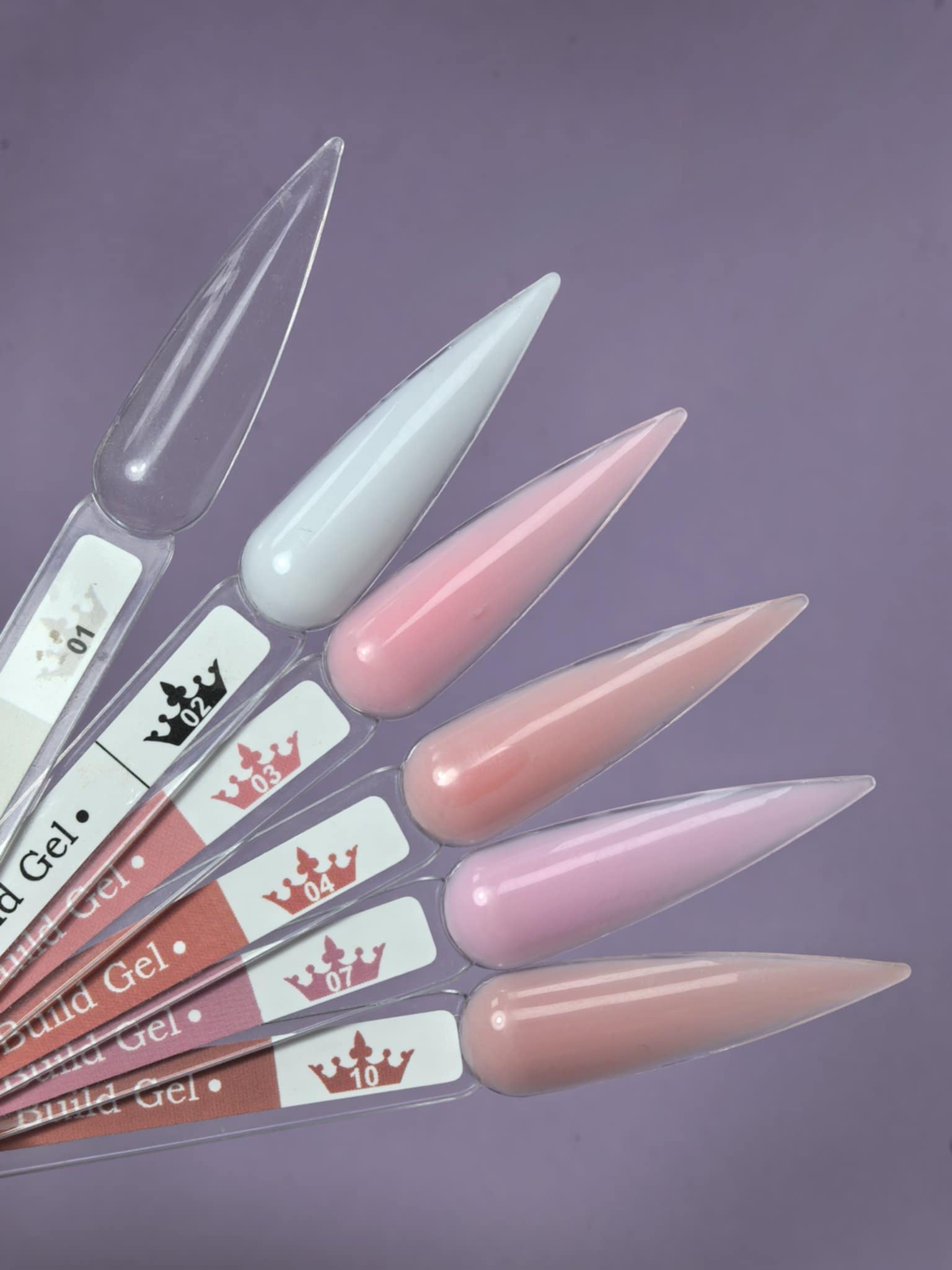 Nail tips with various shades including clear, featuring Lemmy Builder Gel 01 - Clear 15ml for manicure applications.