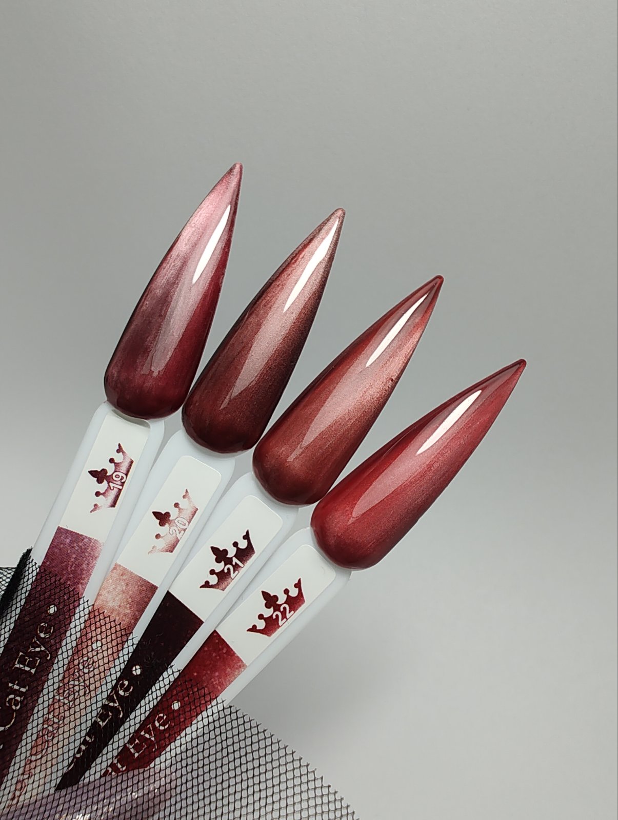 Гел лак Lux Cat Eye - 19 в червено розови нюанси и медно кафеви отенъци, показан на мостри с ефект на котешко око.